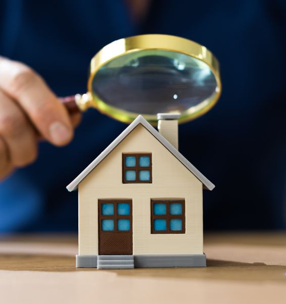 man holding a magnifying glass above a house model valley stream ny