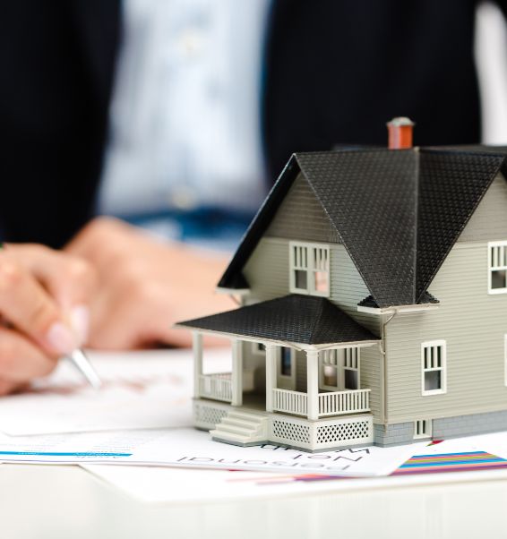 real estate agent writing on papers with house model on table 2 valley stream ny